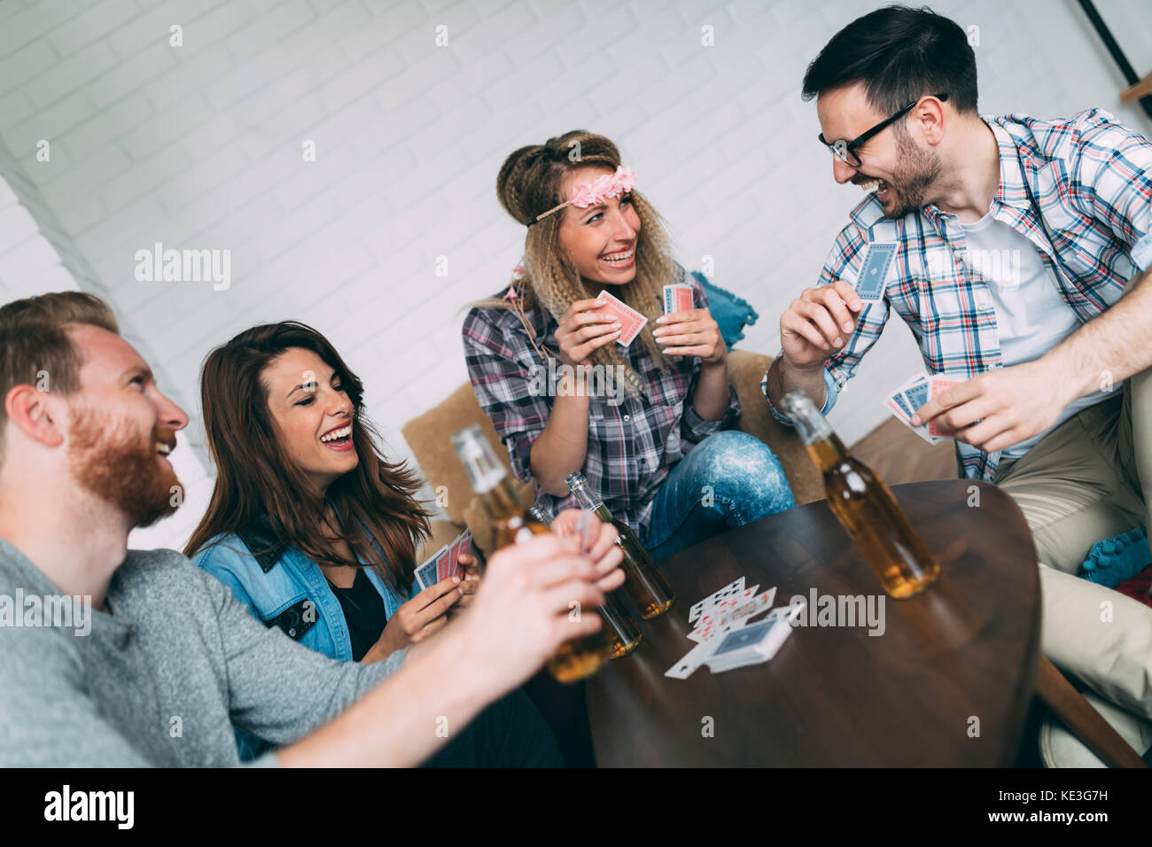 Felice gruppo di amici a giocare a carte e bere Foto Stock