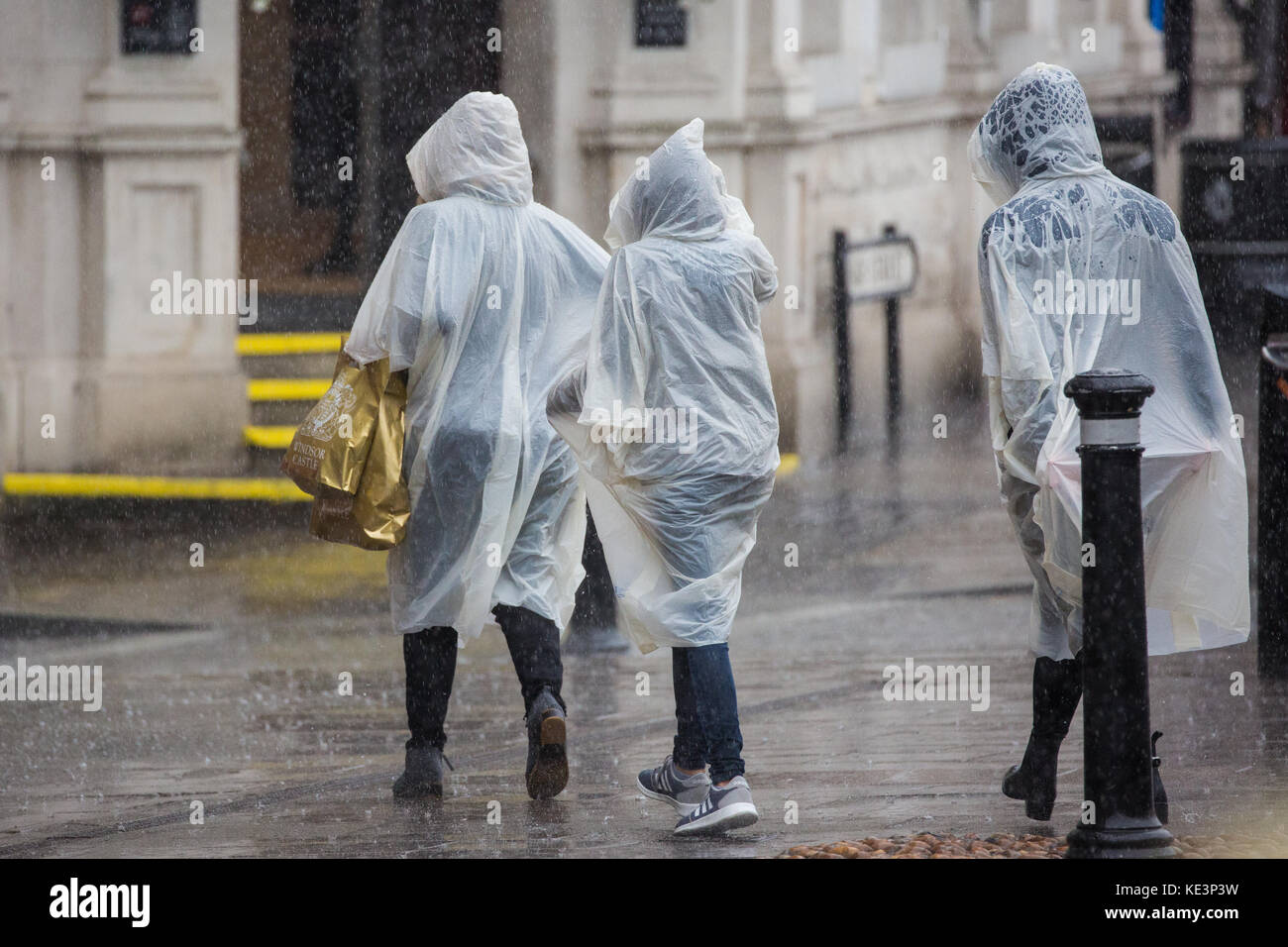 Windsor, Regno Unito. Xviii oct, 2017. i turisti a scomparsa che indossano ponchos lasciare il castello di Windsor durante un improvviso acquazzone. il ramo di ritorno della cerimonia del cambio della guardia dal 1° battaglione delle guardie coldstream è stata annullata in seguito molto heavy rain. Credito: mark kerrison/alamy live news Foto Stock