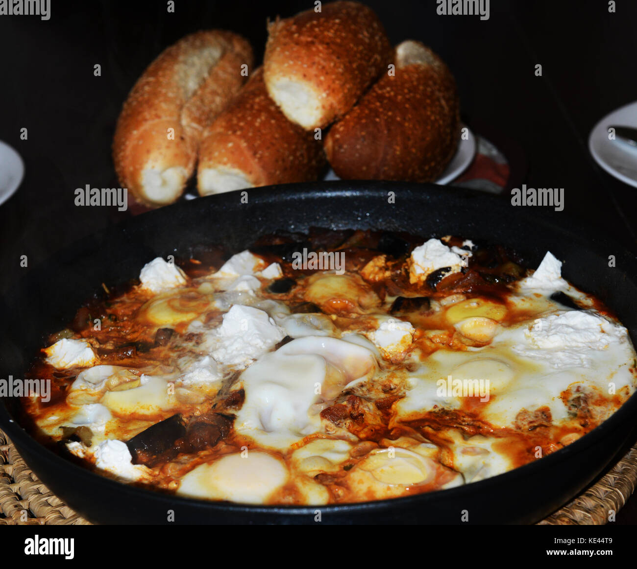 Shakshuka servita con pane fresco. Shakshuka è una rinomata prima colazione piatto in Israele. Il piatto proviene dalla Tunisia in nord Africa. Foto Stock