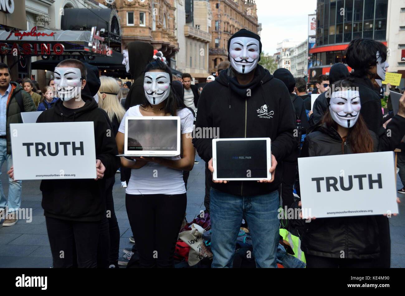 I membri del gruppo anonimo tenendo premuto fino "verità" cartelloni, Londra, Regno Unito. Foto Stock