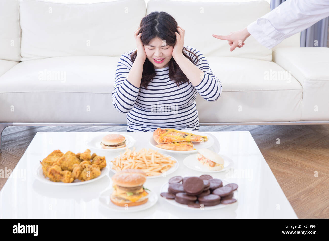Ritratto di giovane stressante donna grassa con fast-food e dolci Foto Stock