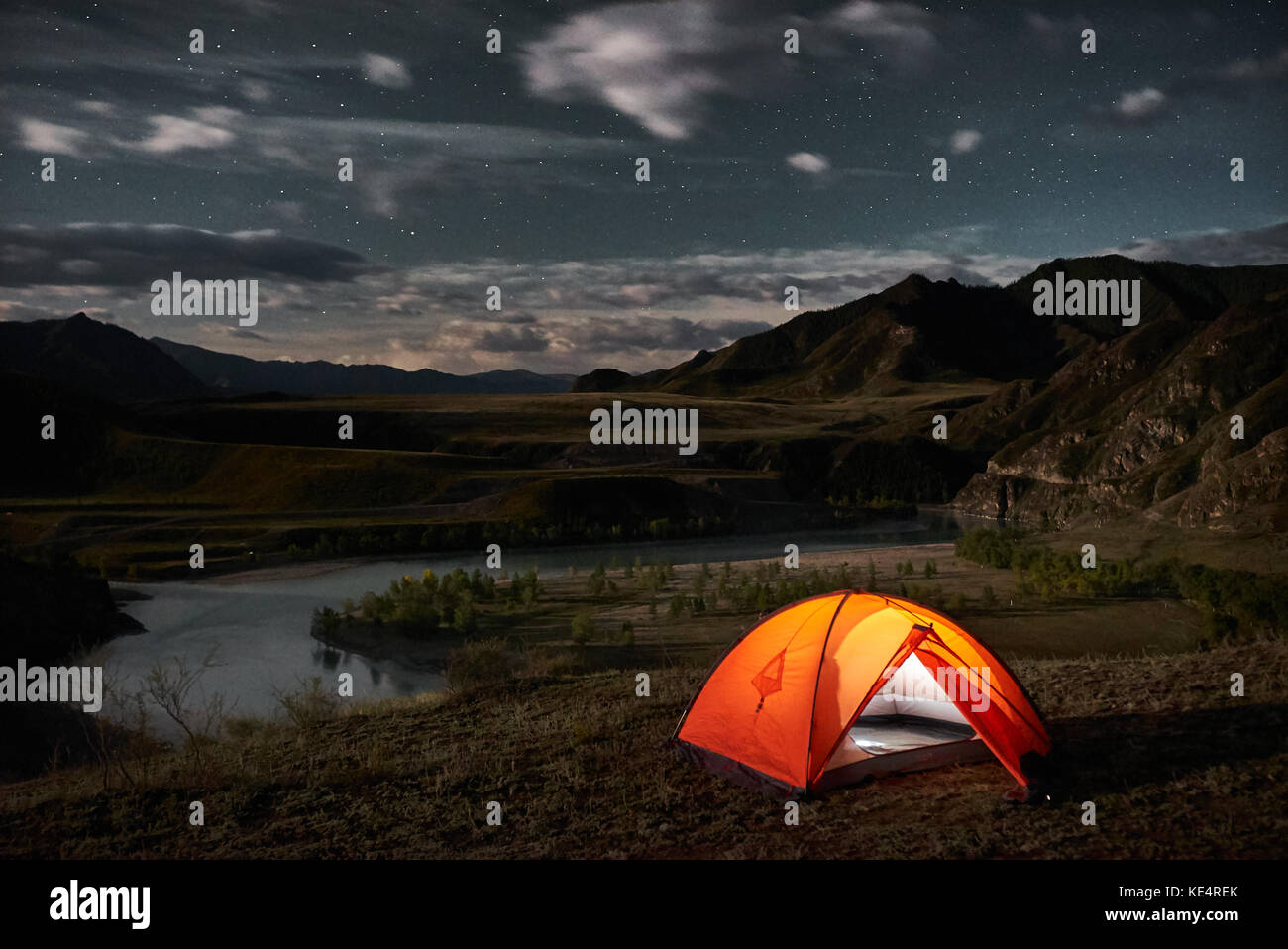 Una tenda si illumina sotto un cielo notturno Foto Stock