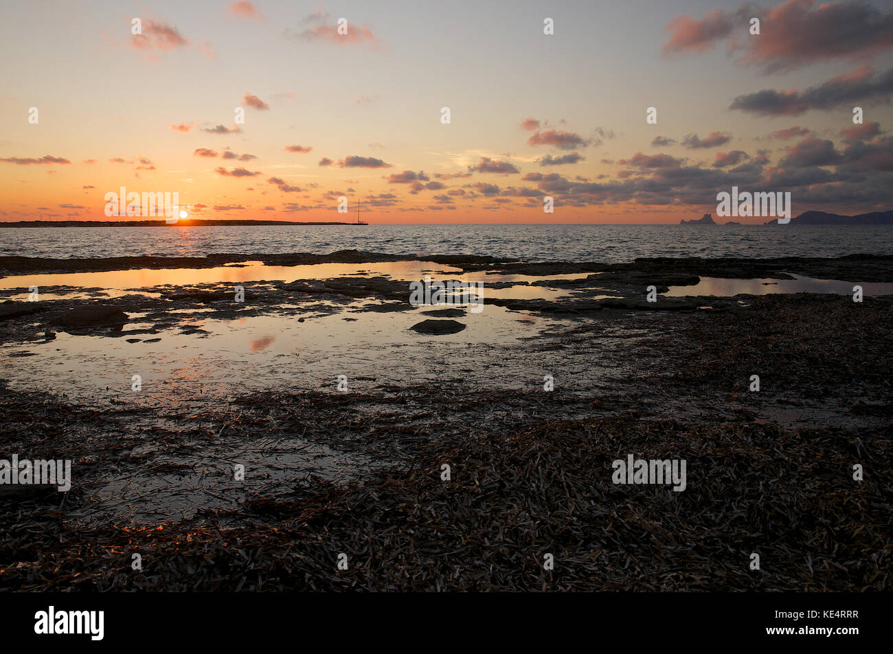 Tramonto a Formentera seashore, vista panoramica di Es Vedrá e Ibiza Isole (Isole Baleari, Spagna) Foto Stock