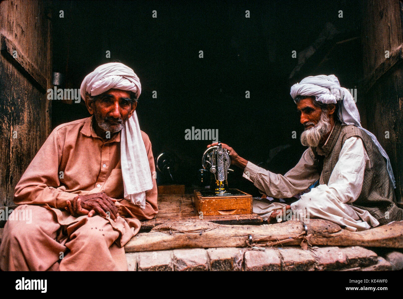 Un sarto e un suo amico, nel suo negozio nella città vecchia di Peshawar, Pakistan Foto Stock Un sarto e un suo amico, nel suo negozio nella città vecchia di Peshawar, Pakistan Foto Stock