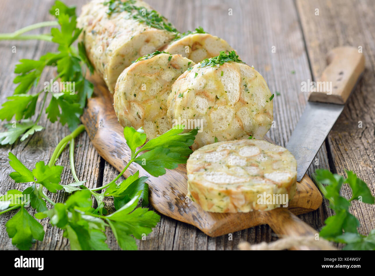 Fette di pane bavarese gnocco , il perfetto piatto di lato per arrosti o strisce di carne con salsa, servita su un tagliere di legno Foto Stock