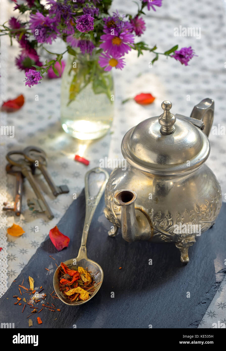 Asciugare le foglie di tè sul cucchiaio sulla piastra di ardesia Foto Stock