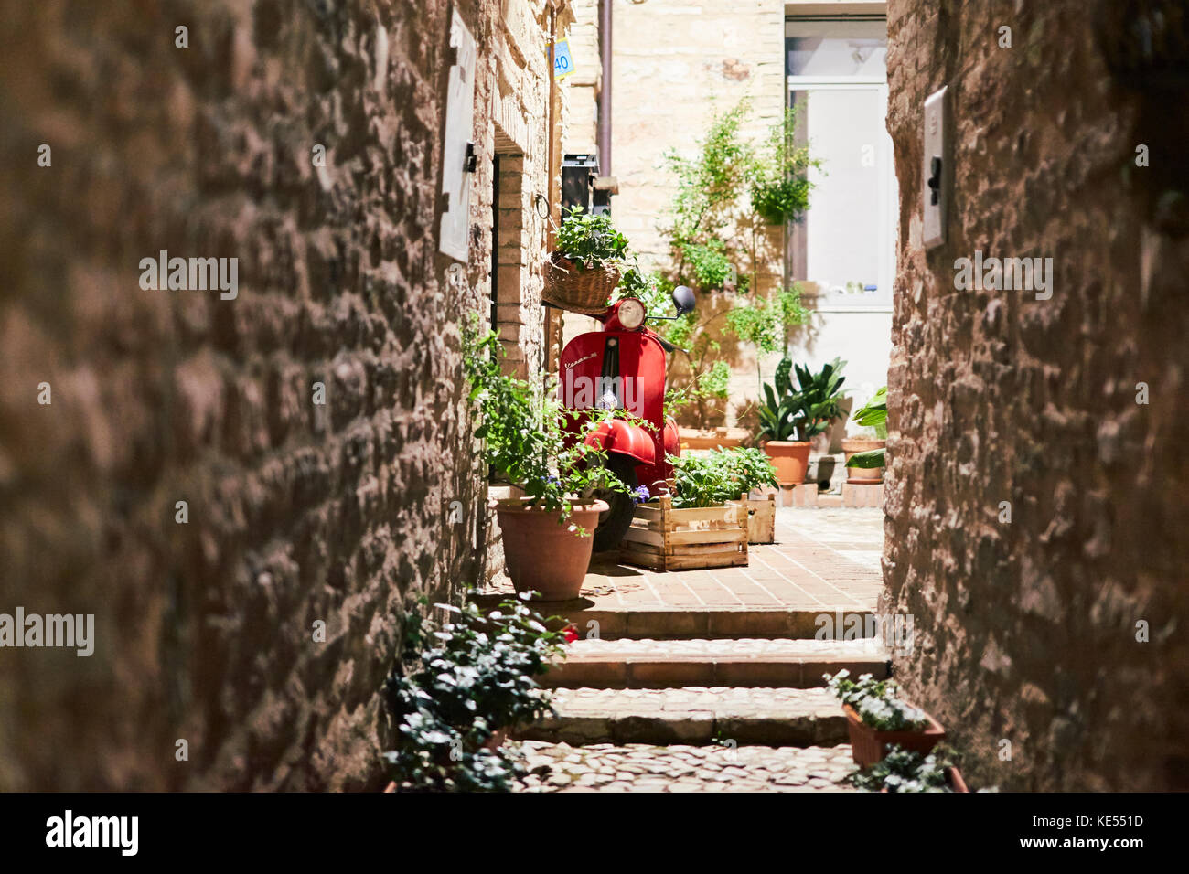Rosso Piaggio Vespa in un vicolo medievale - Spello Foto Stock