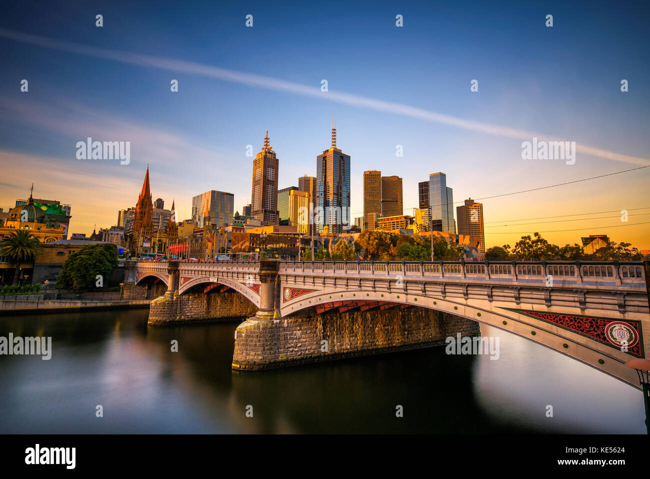 Tramonto sulla skyline del centro cittadino di Melbourne, la principessa e il ponte sul fiume Yarra Foto Stock