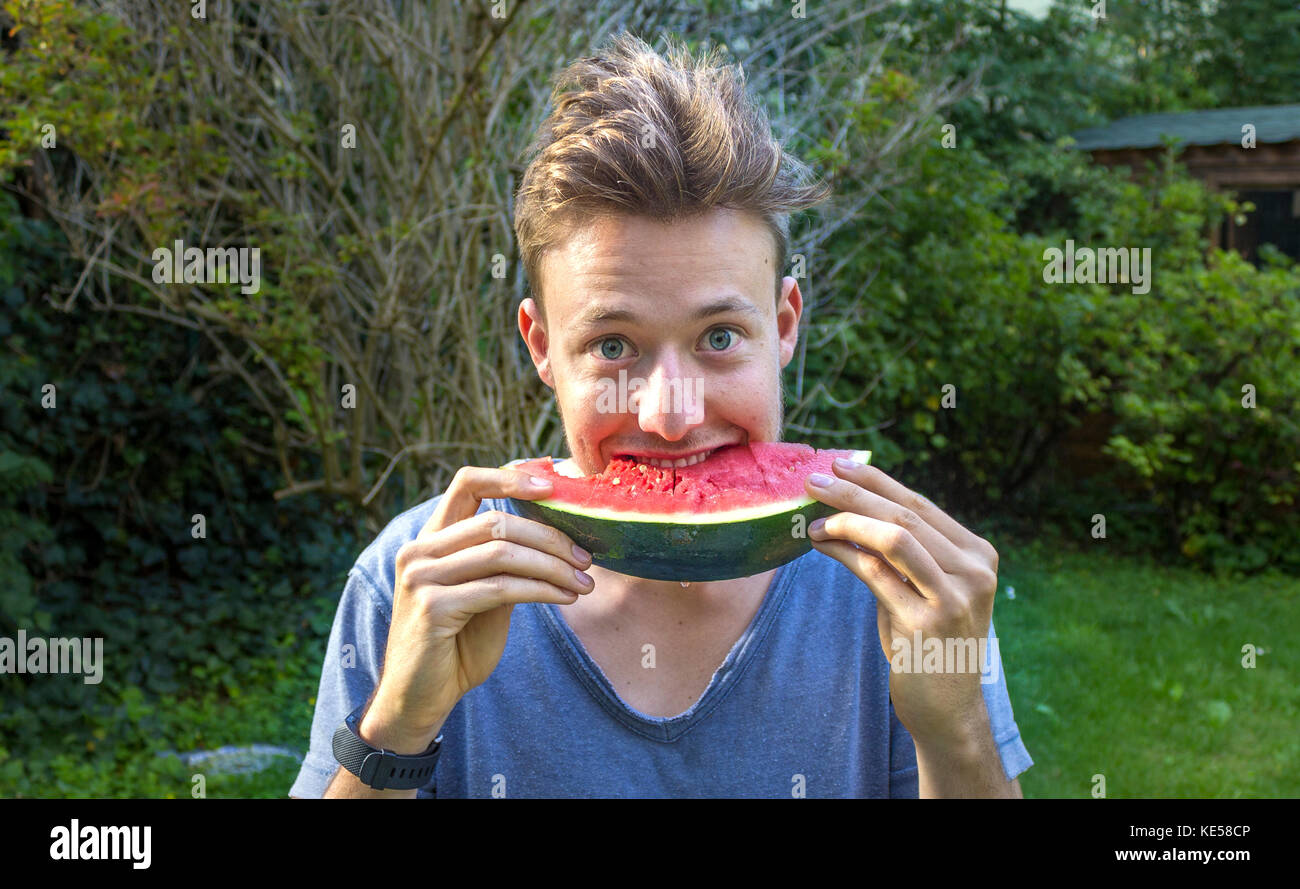 Giovane uomo mangiare un melone, Baviera, Germania Foto Stock