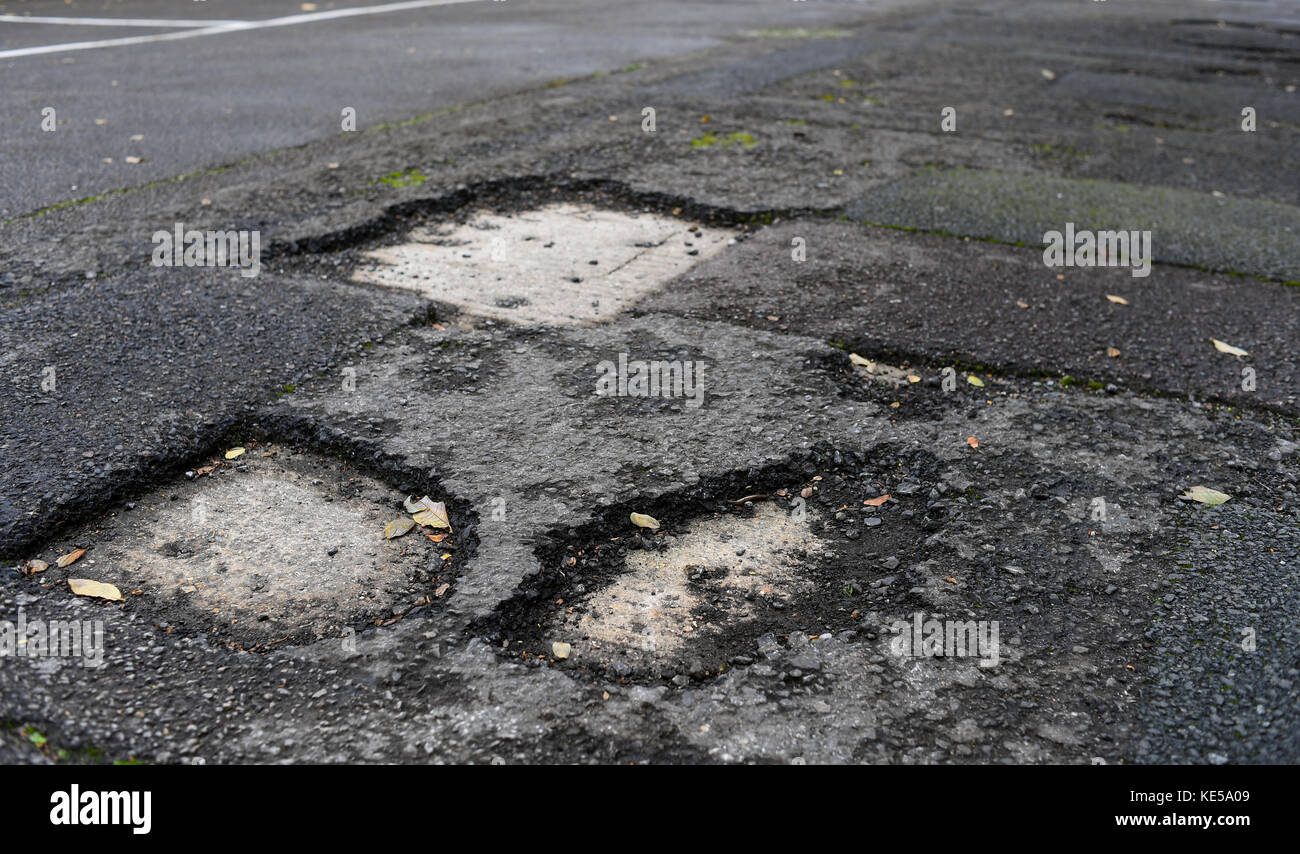 Buca in strada causando la miseria per automobilista Foto Stock