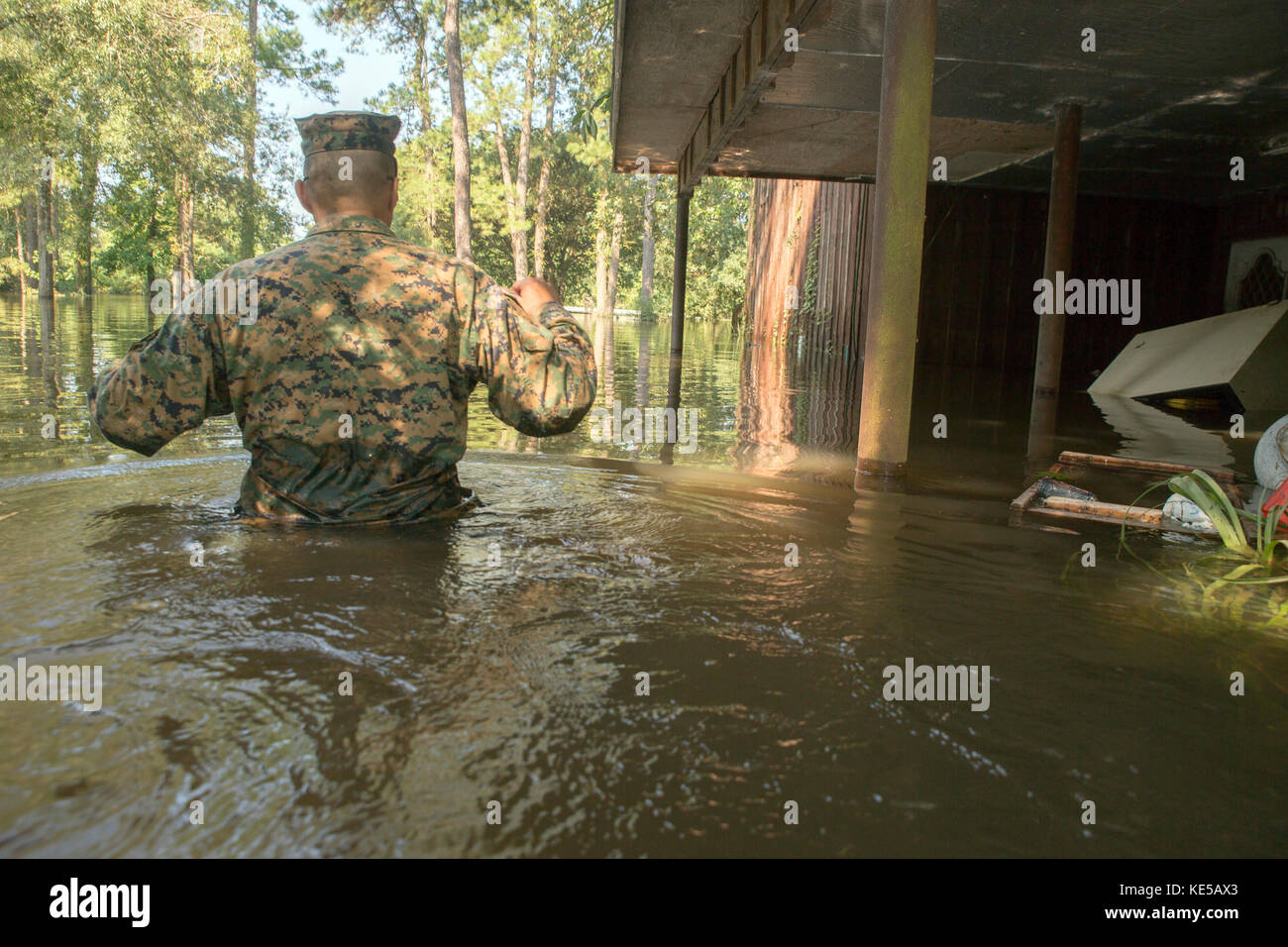 Un us marine wades attraverso waist deep acqua di inondazione durante l uragano Harvey. Foto Stock