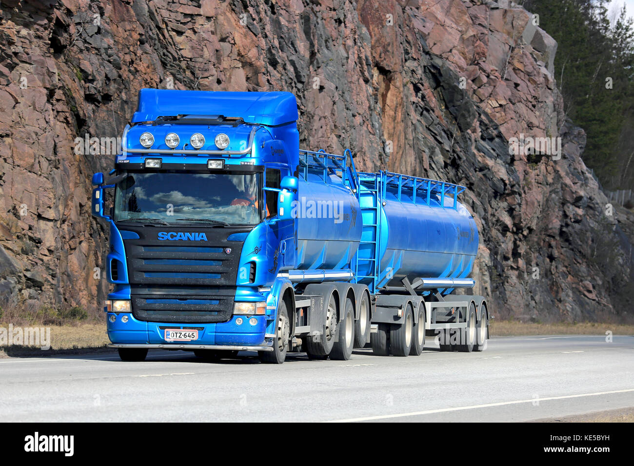 Karjaa, Finlandia - 10 aprile 2016: blu scania r500 autobotte si muove lungo l'autostrada, con parete di roccia sullo sfondo. Foto Stock