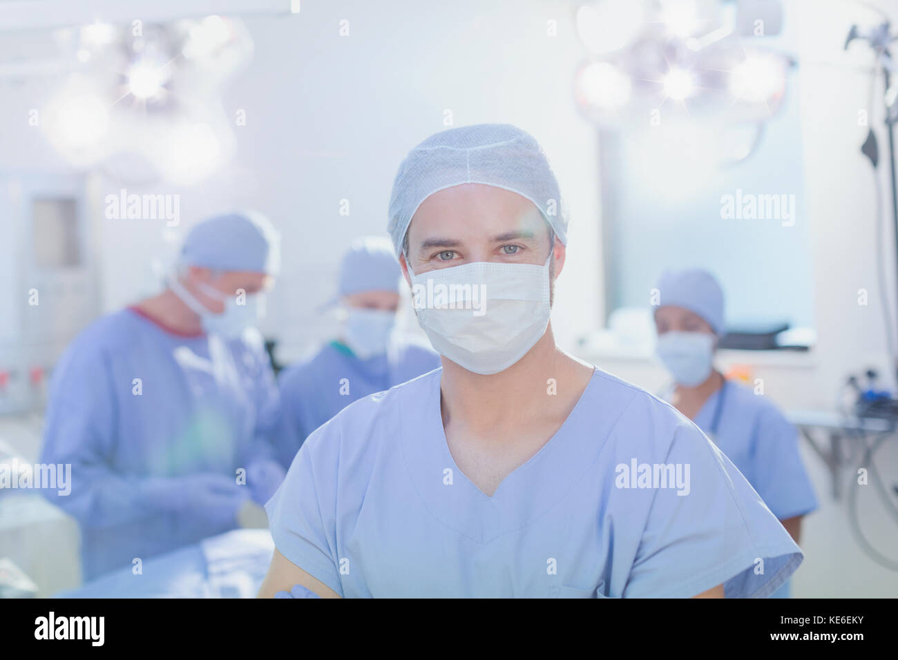 Ritratto sicuro giovane chirurgo maschile indossando maschera chirurgica in funzione camera Foto Stock