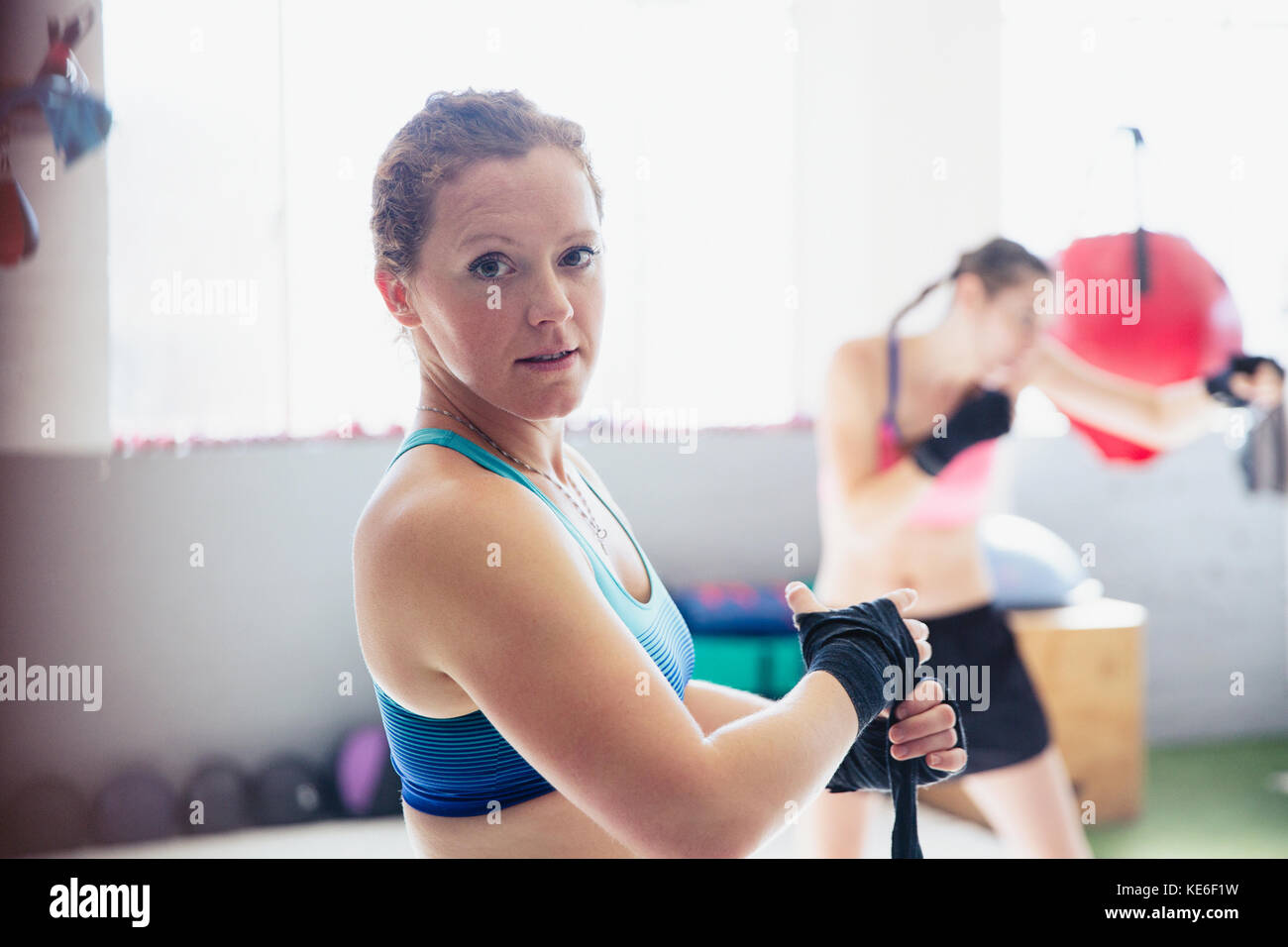 Pugile sicuro di ritratto, duro che avvolge i polsi in palestra Foto Stock