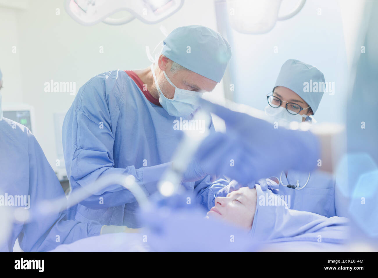 Chirurghi che operano su pazienti di sesso femminile in sala operatoria Foto Stock