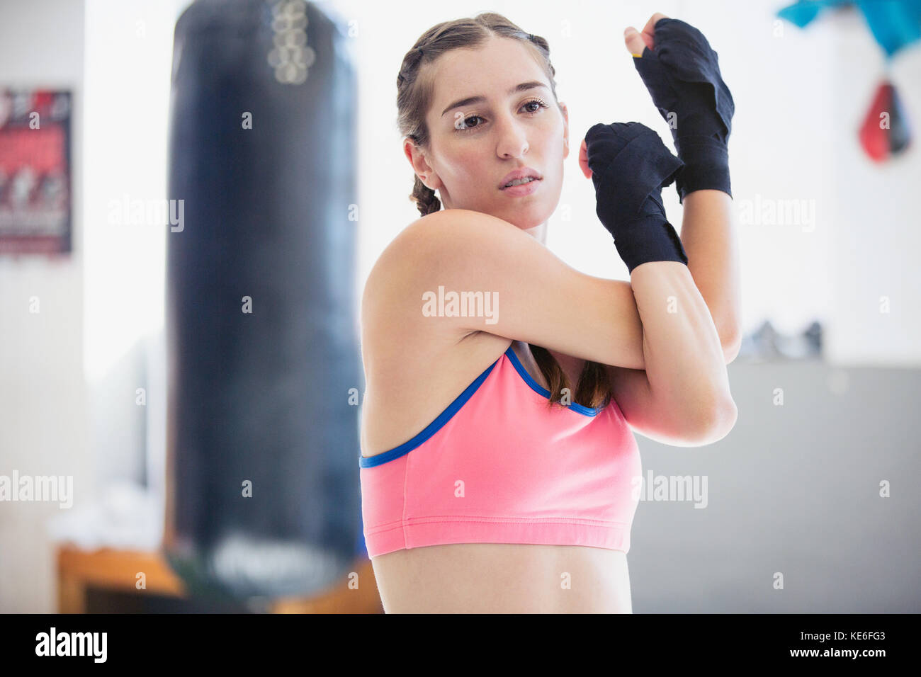 Boxer giovane femmina che allunga le spalle e le braccia in palestra Foto Stock