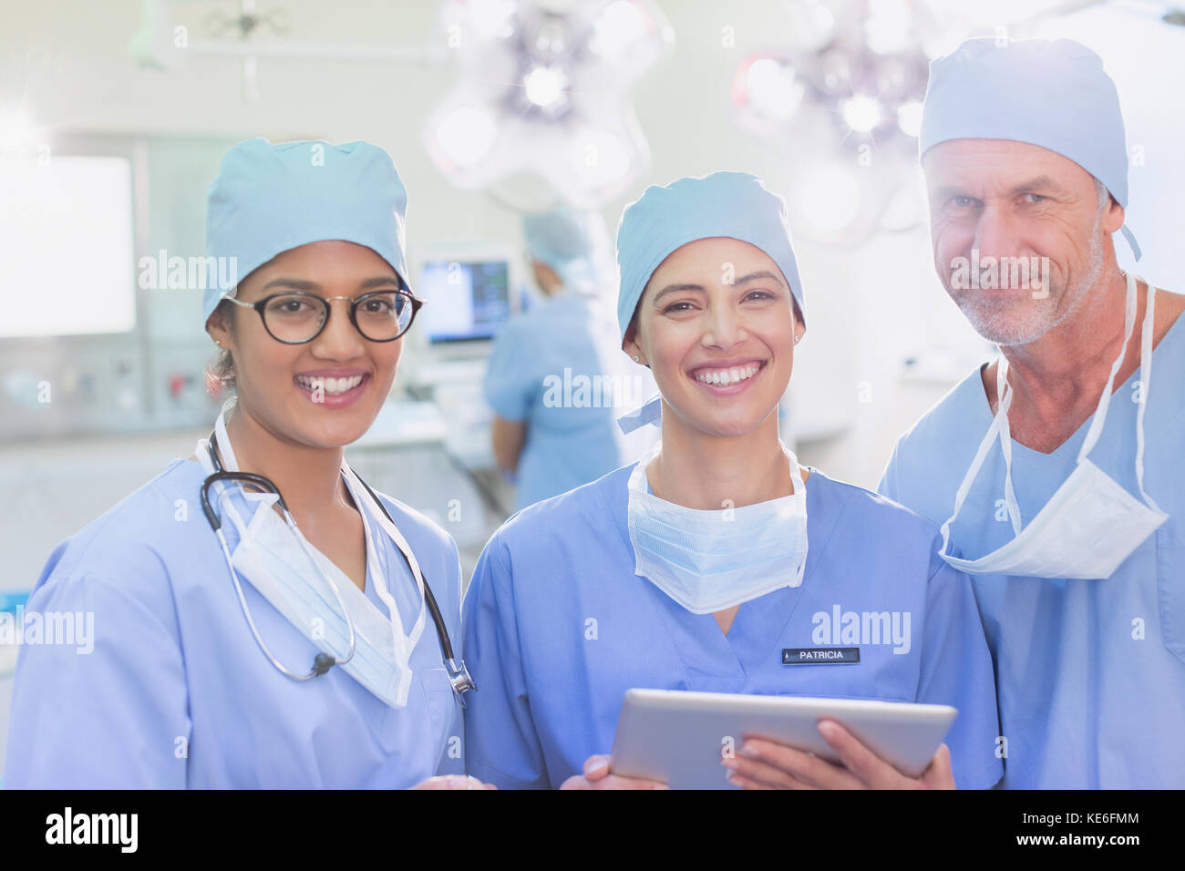 Ritratti chirurghi sorridenti e sicuri utilizzando un tablet digitale in sala operatoria Foto Stock