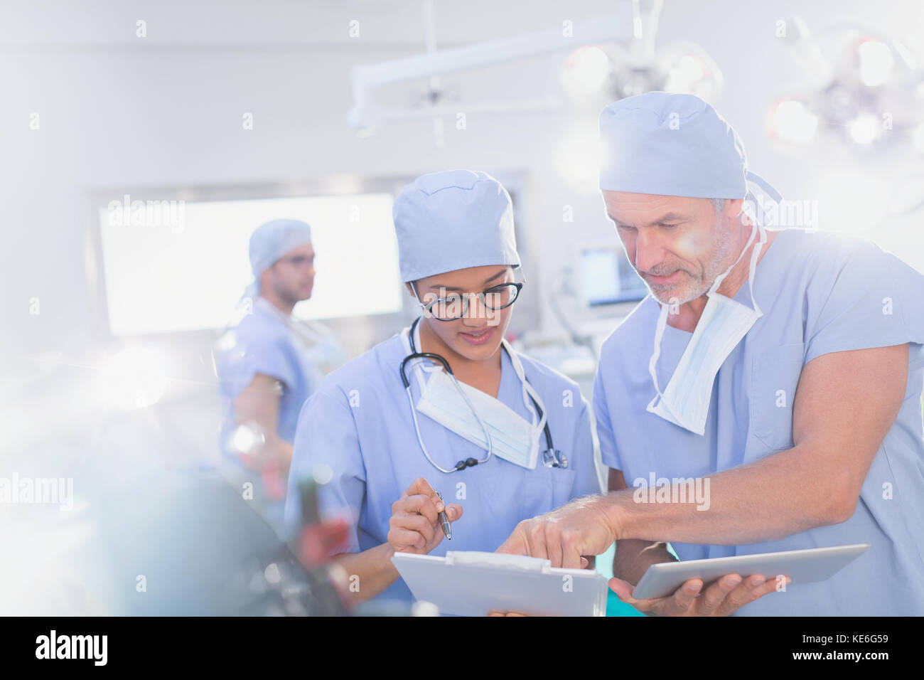 Chirurghi con tablet digitale che parlano di documenti sulla clipboard in funzione camera Foto Stock