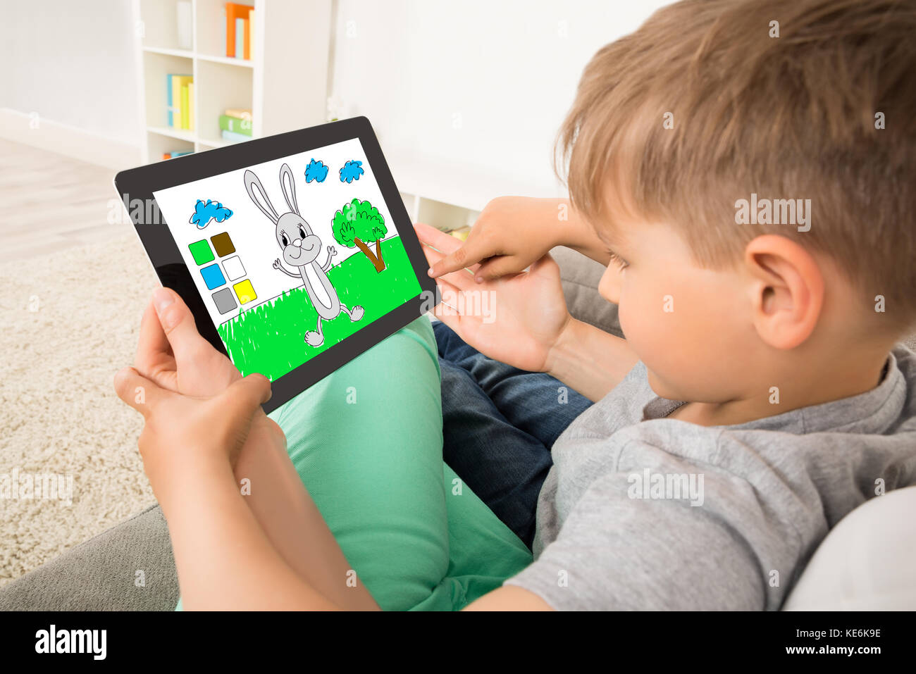 Close-up di Little Boy Playing Game sulla tavoletta digitale Foto Stock