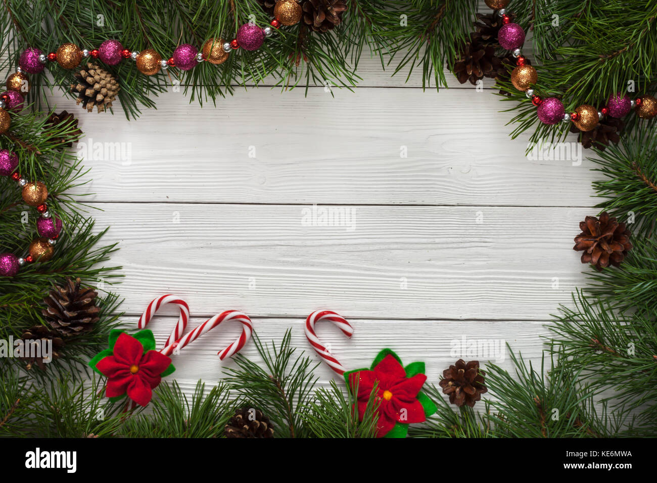 Modello di scheda di natale con abete di confine e spazio copia. tavolo in legno naturale e rami di pino. Foto Stock