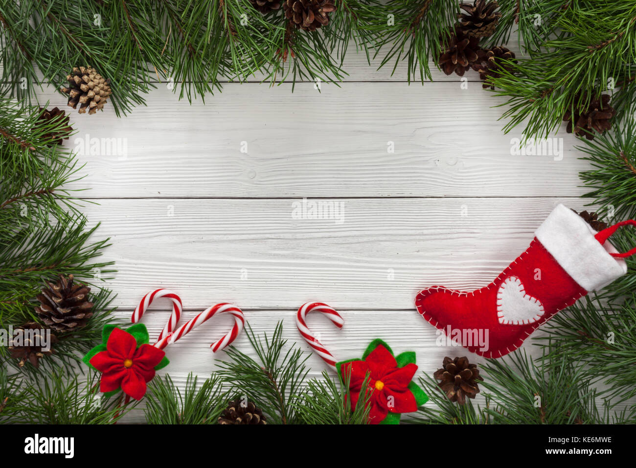 Modello di scheda di natale con abete di confine e spazio copia. tavolo in legno naturale e rami di pino. Foto Stock