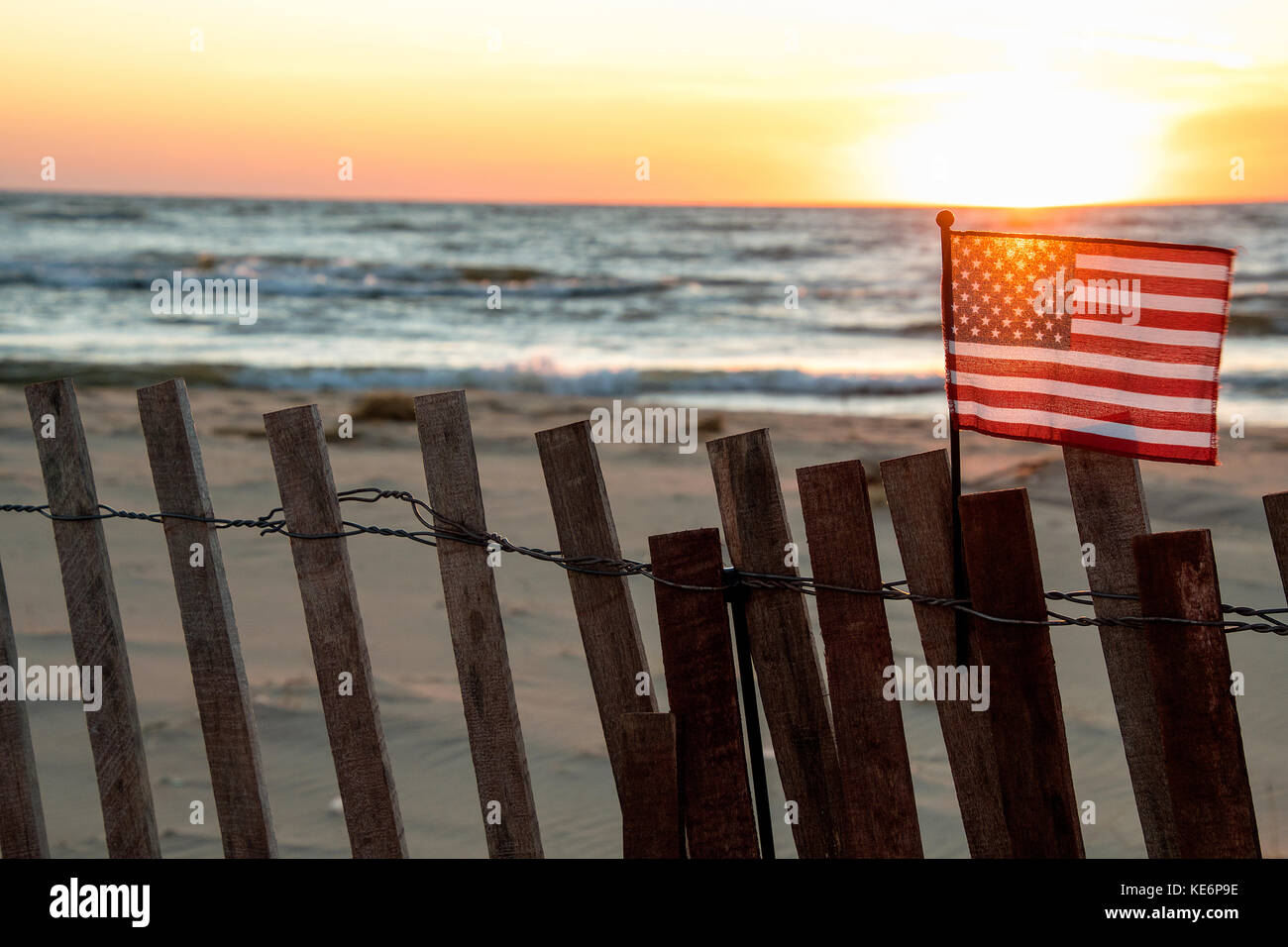 Sunset glow in bandiera americana sulla spiaggia recinto con il lago michigan sfondo Foto Stock