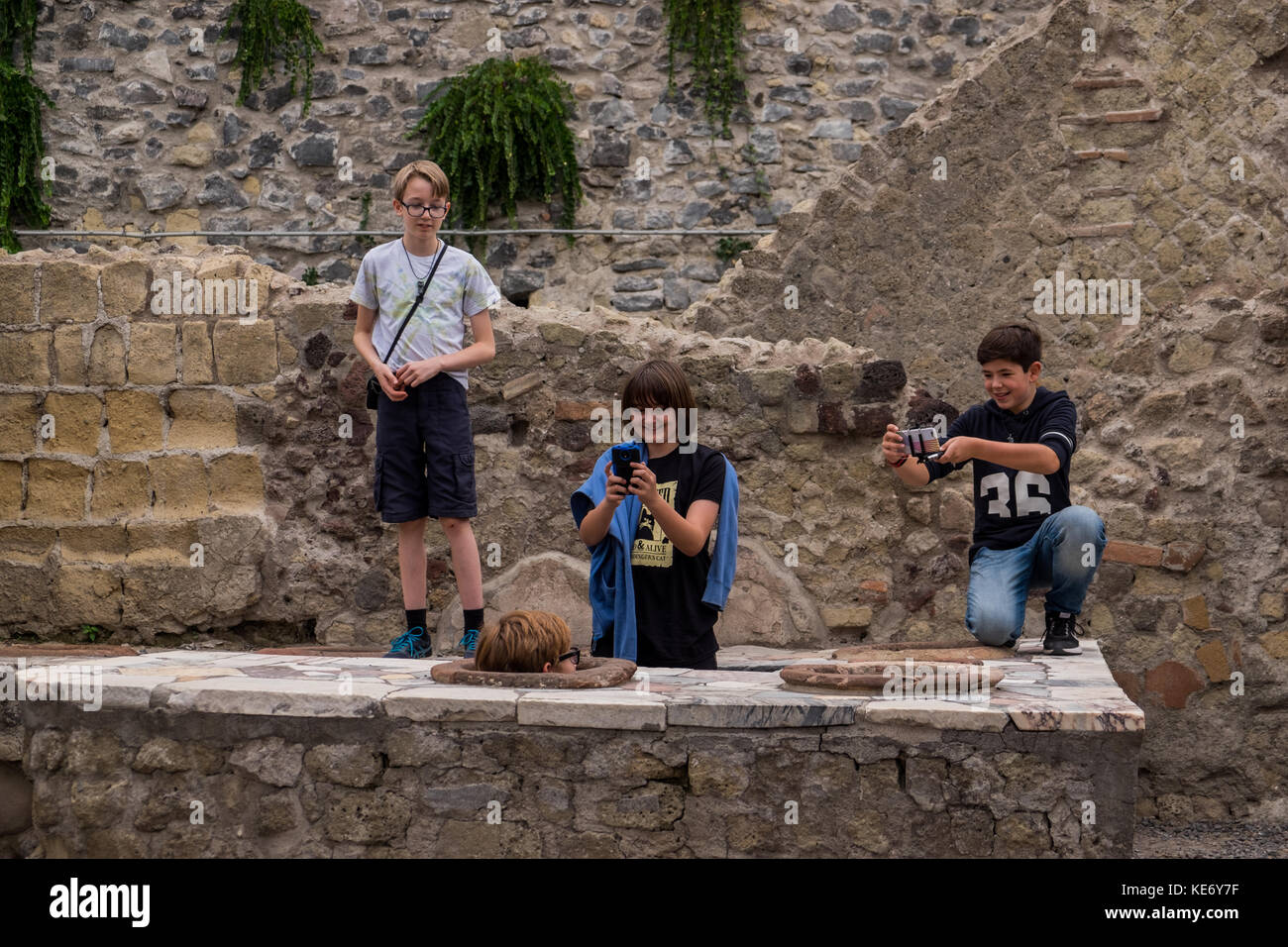 Bambini che giocano al sito archeologico di un minuto prima di essere cacciati fuori del sito Foto Stock