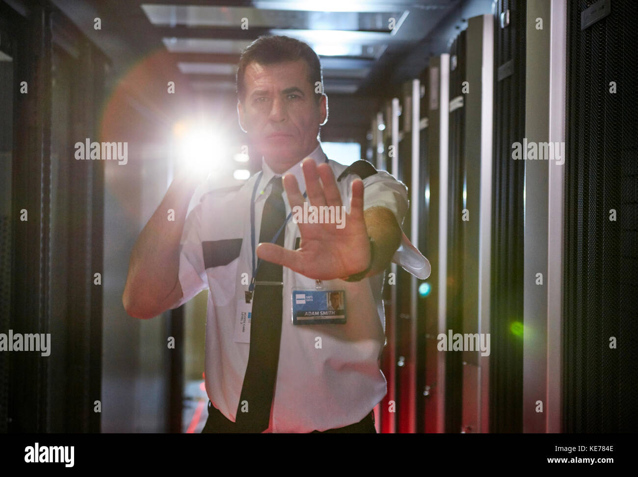 Portrait maschile guardia di sicurezza con torcia gesturing stop in server camera Foto Stock