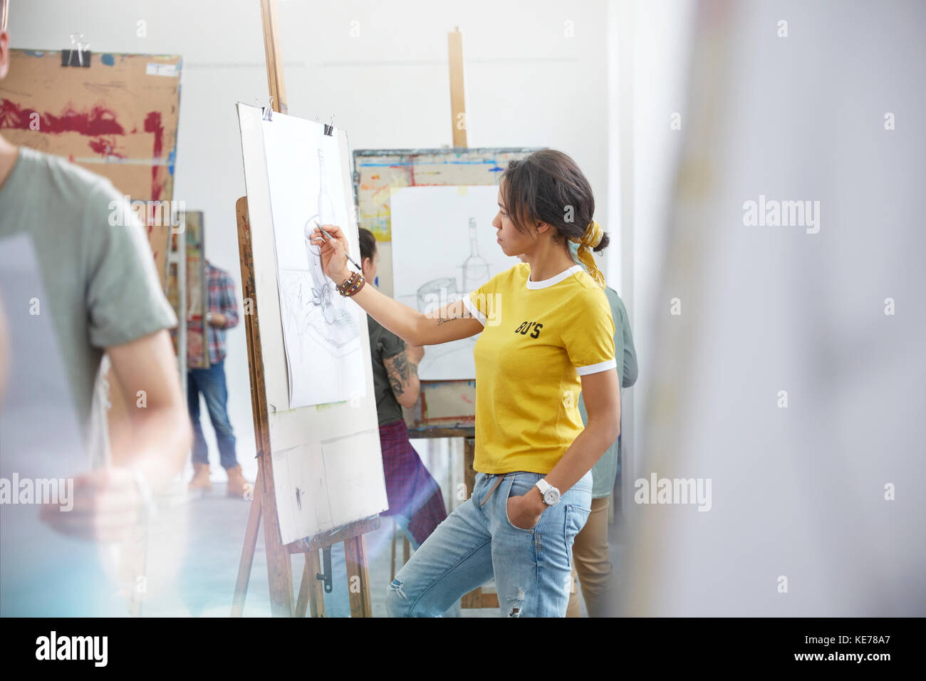 Artista femminile delineando al cavalletto in classe d'arte studio Foto Stock