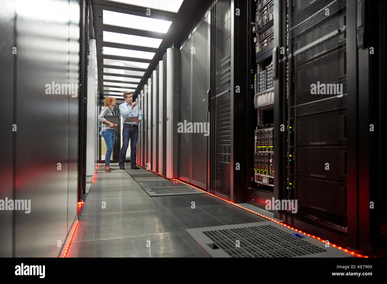 Tecnici IT che parlano al pannello nella sala server Foto Stock