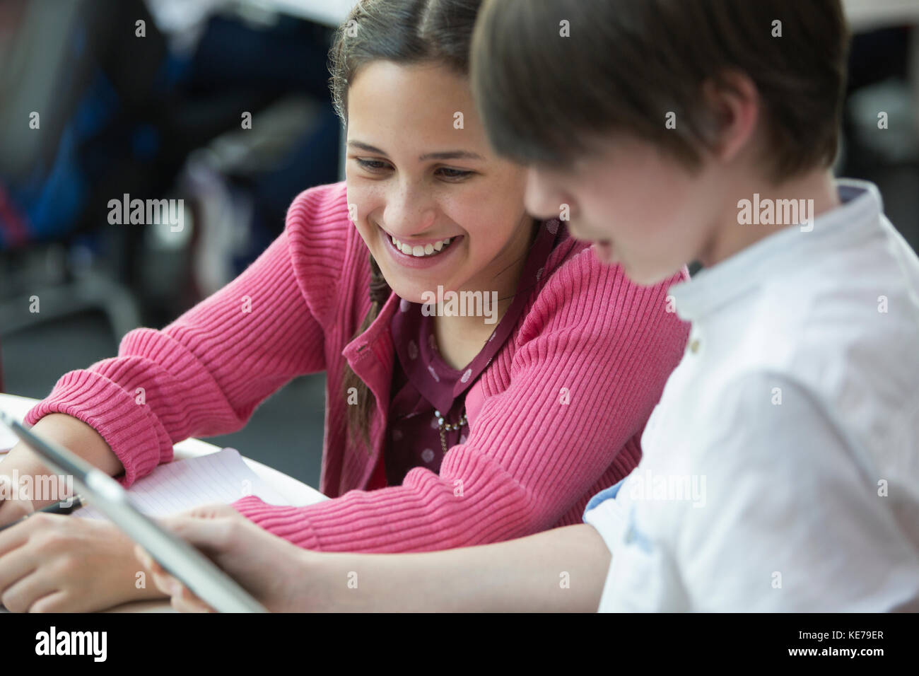 Sorridendo gli studenti che usano il tablet digitale in classe Foto Stock