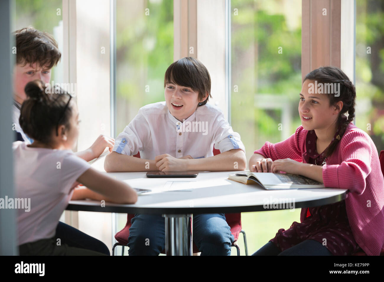Studenti che parlano al tavolo in biblioteca Foto Stock