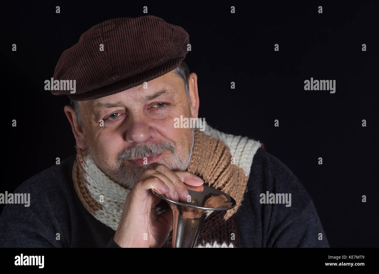 Bel ritratto di pensionati senior sorridente uomo prendendo una vecchia tromba nelle tenebre Foto Stock