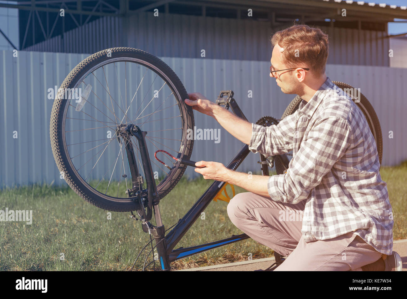 L'uomo utilizza una pompa da bicicletta. il gonfiaggio del pneumatico di una bicicletta. ciclista riparazioni bici in viaggio. Foto Stock