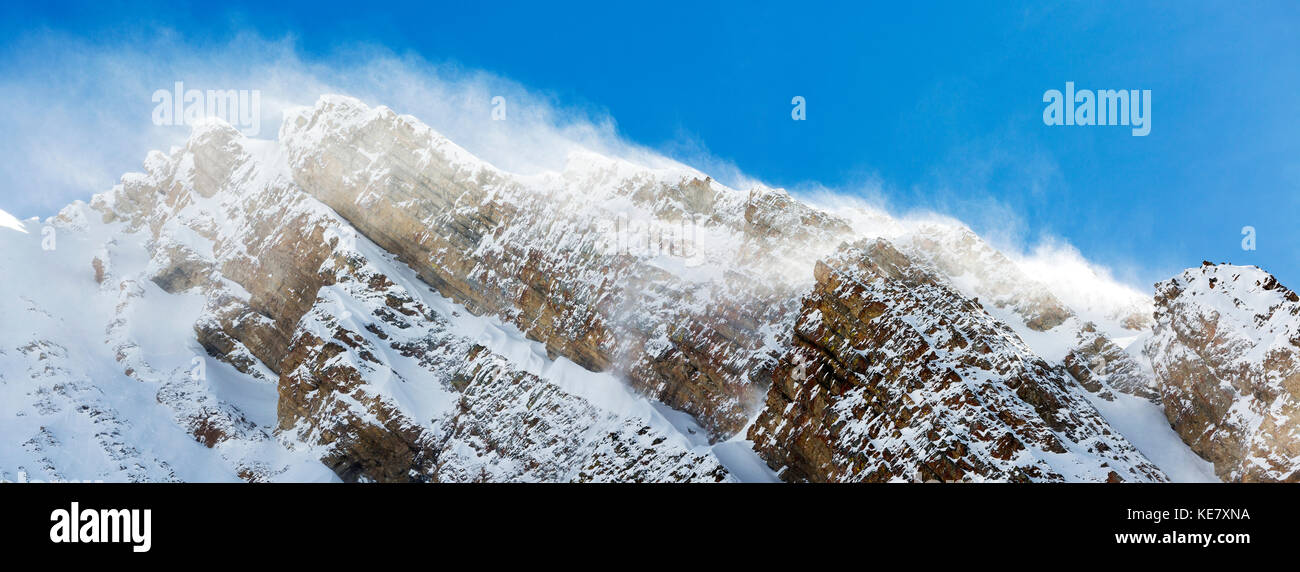 In primo piano di una coperta di neve picco di montagna con lavori di soffiaggio della neve e cielo blu, Peter Lougheed Parco Provinciale; Alberta, Canada Foto Stock