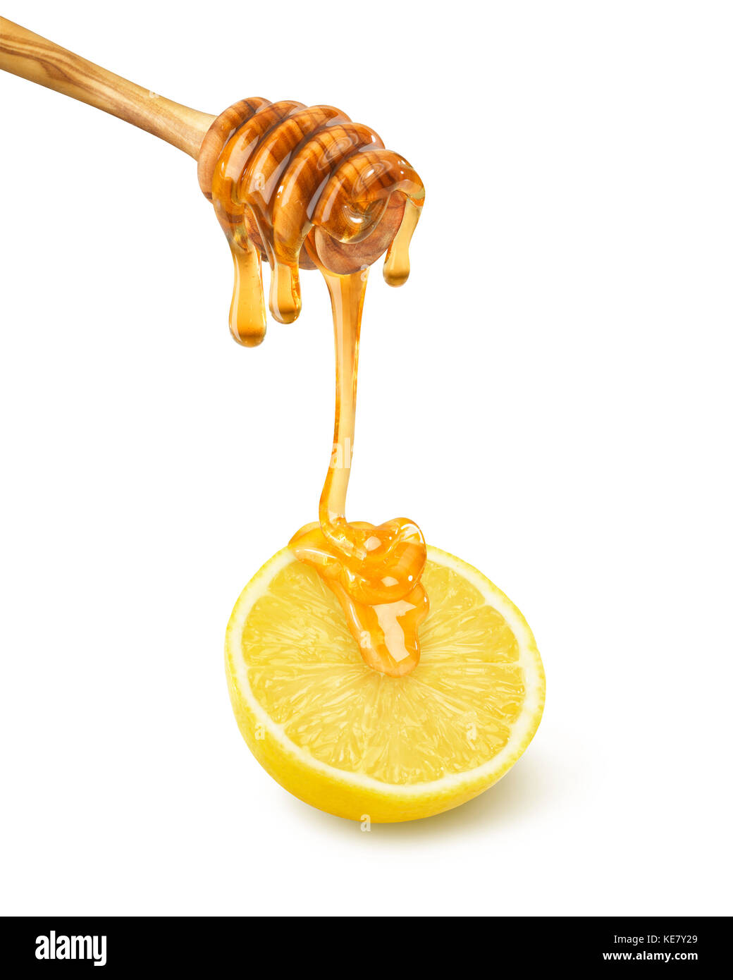 Il miele il gocciolamento da un bilanciere su un mezzo limone su sfondo bianco Foto Stock