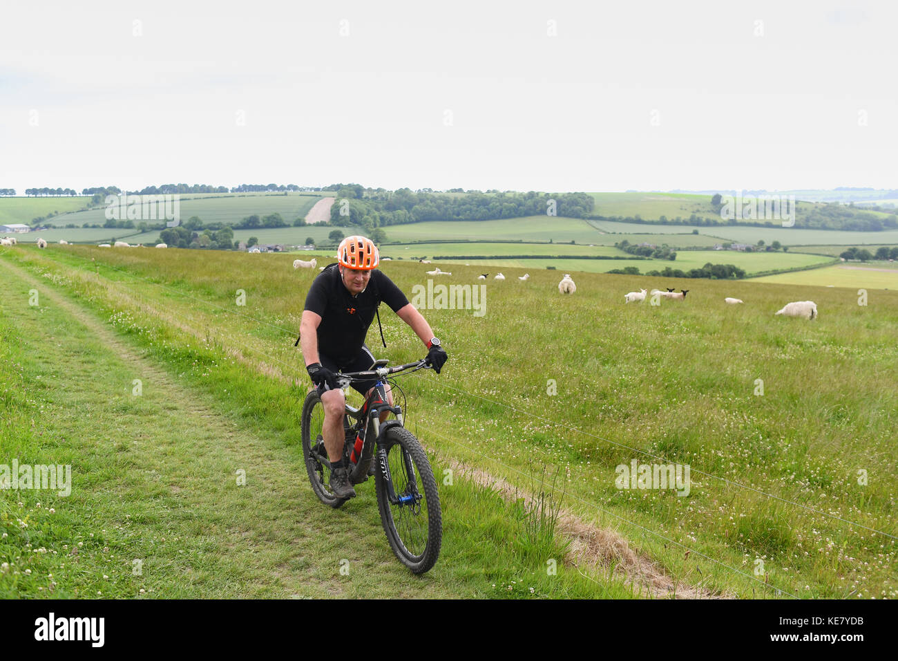 Un lone mountain biker scorre attraverso il South Downs modo un sentiero che corre da Winchester a Eastbourne Foto Stock