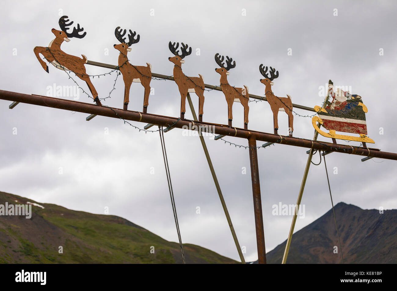 Questa scena decorativa fuori luogo di Babbo Natale con la sua slitta renna è attaccato ad un palo luminoso al campo di manutenzione Chandalar dell'Alaska DOT... Foto Stock