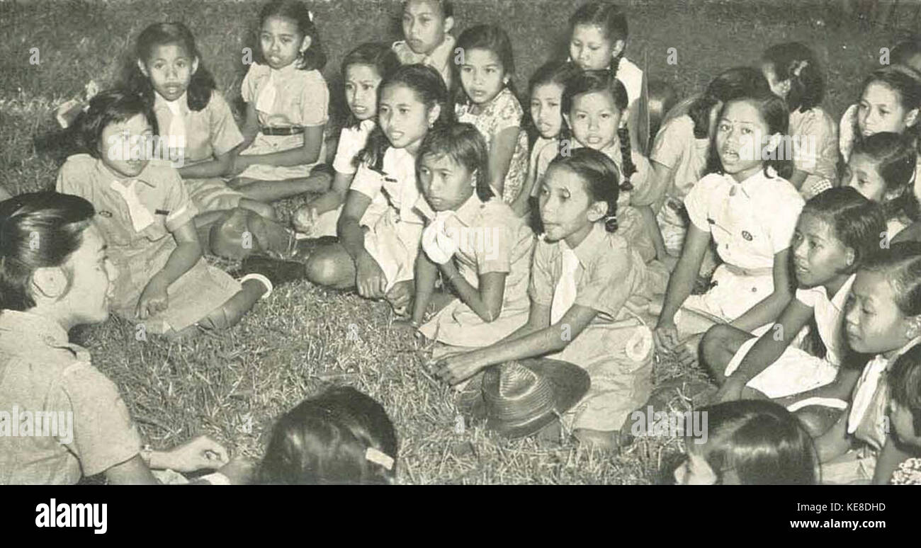Un'immagine che mostra le Girl Scouts in Indonesia che cantano una canzone da falò, riflettendo gli aspetti culturali e organizzativi delle Girl Scouts in Indonesia, probabilmente durante un campo o un'attività all'aperto. Foto Stock