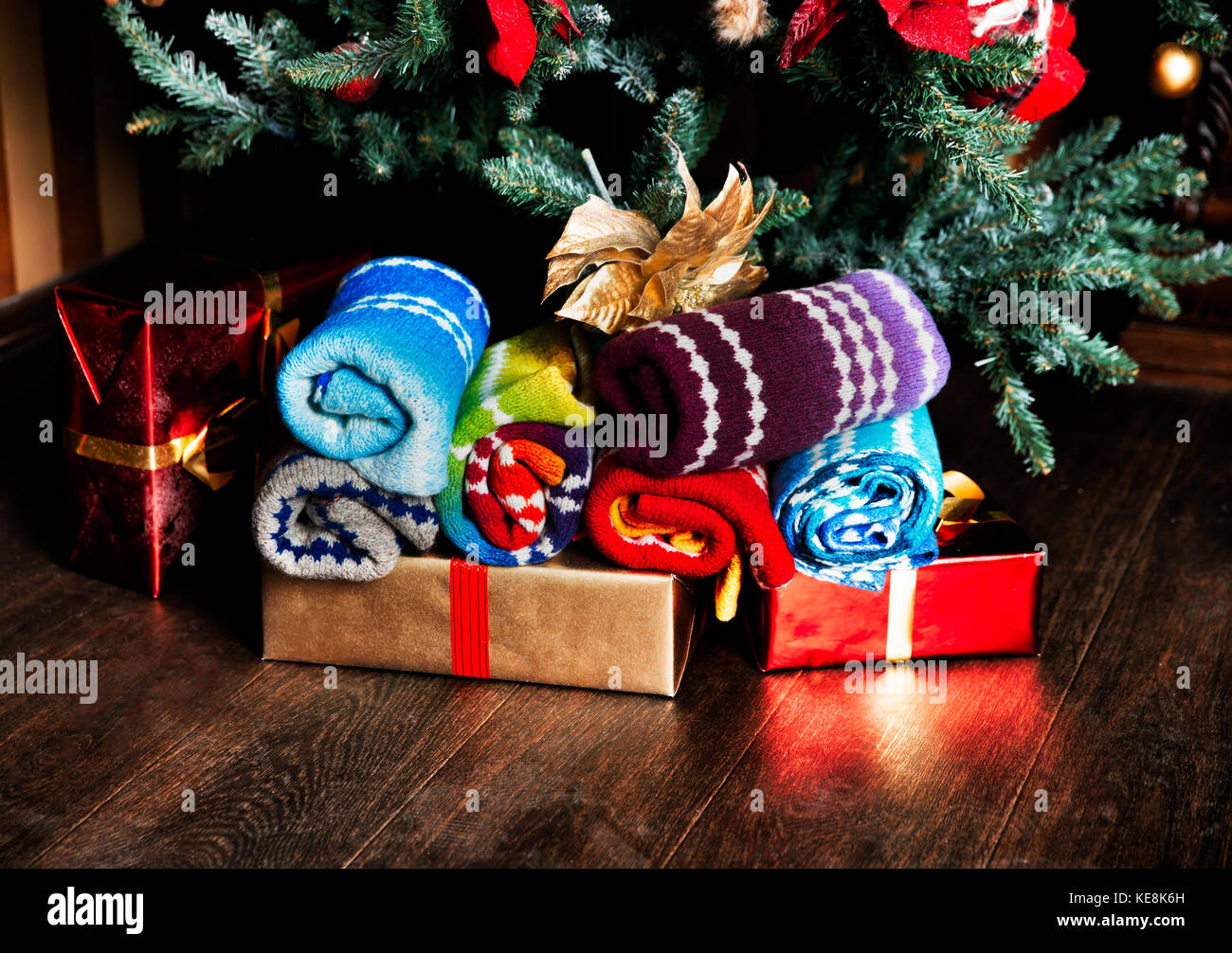 Regali di natale di lana e eco-sciarpe accanto a un albero di natale. regali  di Natale sfondo. Sciarpe fatte di dundaga lana Foto stock - Alamy
