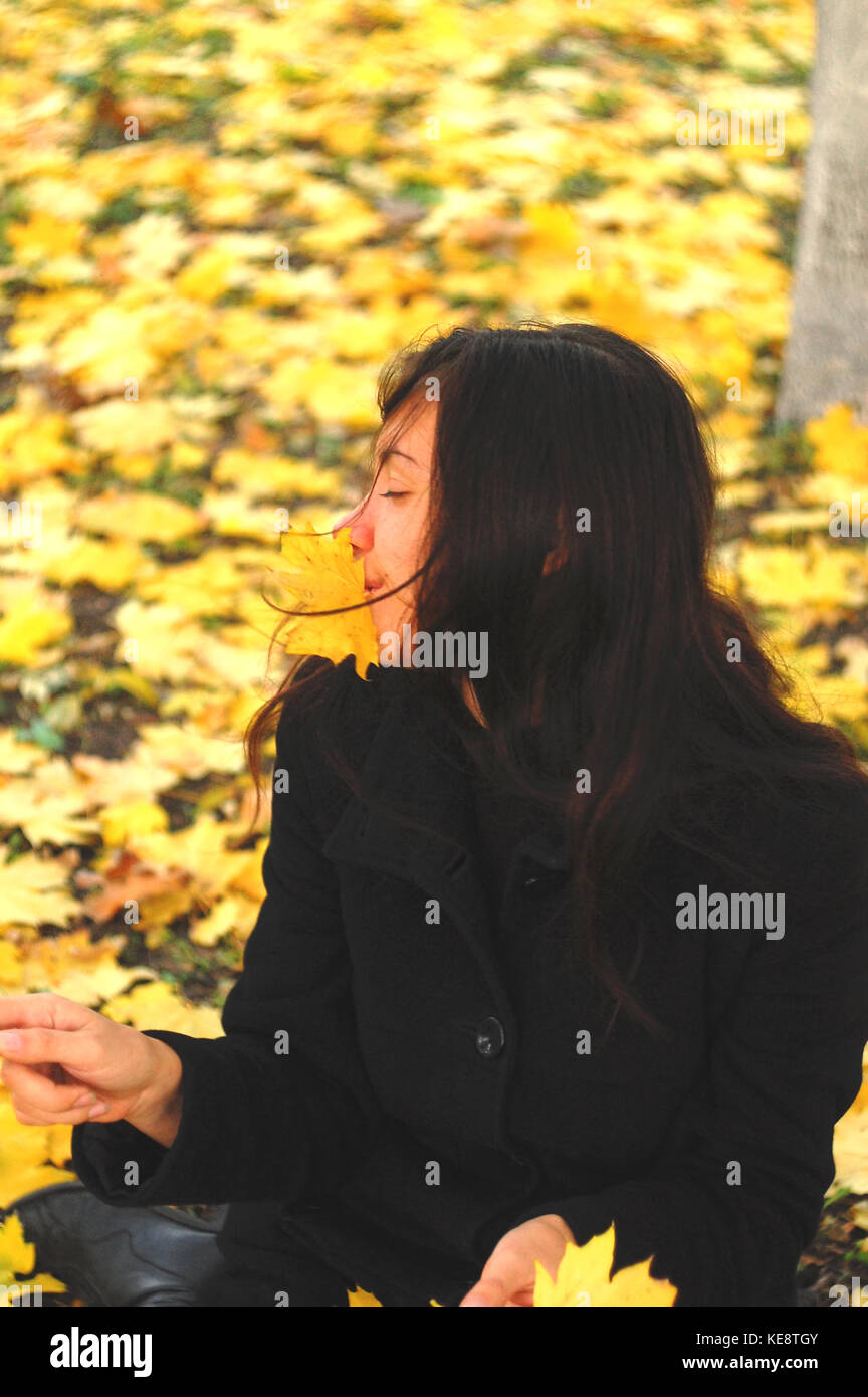 Un divertente giovane ragazza attraente è divertente e ingannare intorno in un parco d'autunno. allegro emozioni, autunno dell'umore. Foto Stock