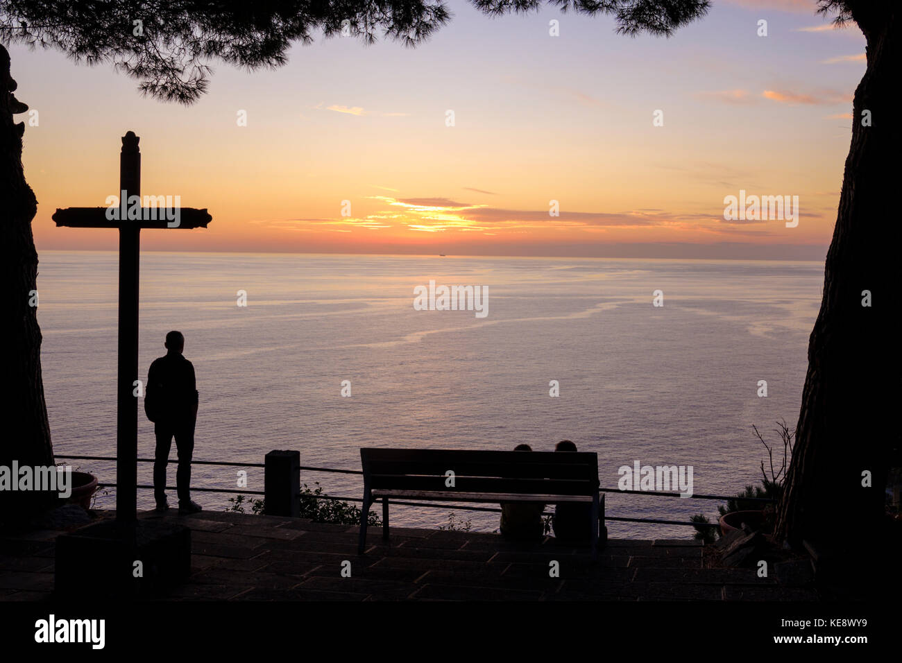 Uomo che guarda il tramonto della costa da una croce da Riomaggiore, cinque Terre, Liguria, Italia Foto Stock