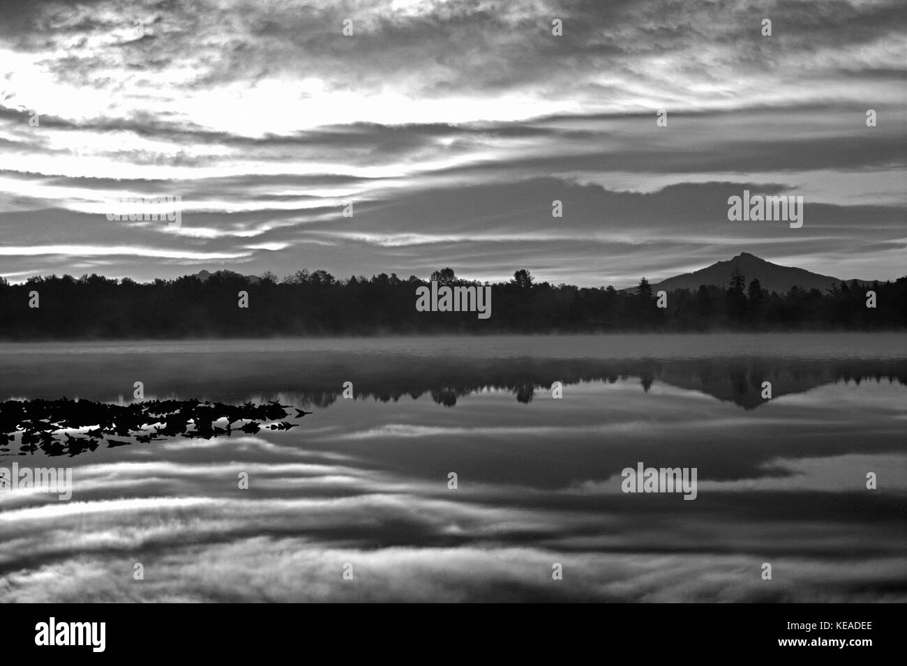 Drammatico tramonto sul Lago Cassidy con montatura Pilchuck riflettente nel lago calmo Early Morning Light, Snohomish County, nello Stato di Washington STATI UNITI D'AMERICA Foto Stock