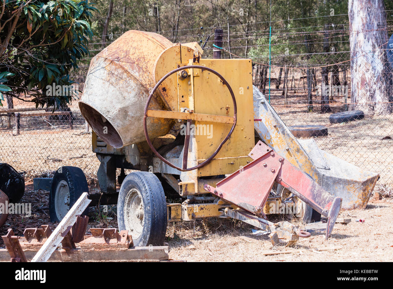 Calcestruzzo macchina di miscelazione del cemento in pietra arenaria con funzionamento manuale indossato utilizzato da costruzione in campo all'aperto. Foto Stock