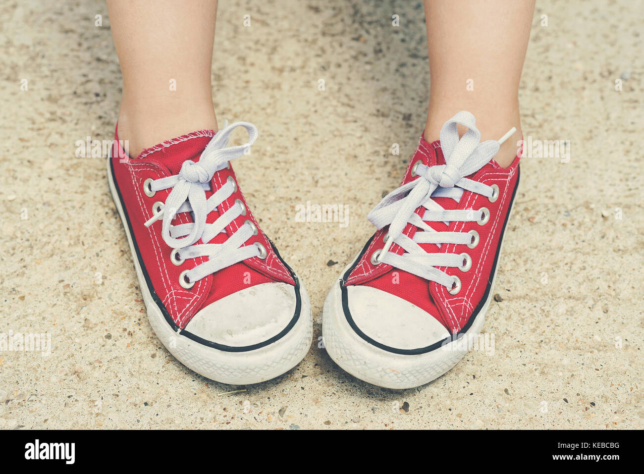 Bambino con sneakers. bambino con red sneakers bambino con sneakers. bambino con red sneakers Foto Stock