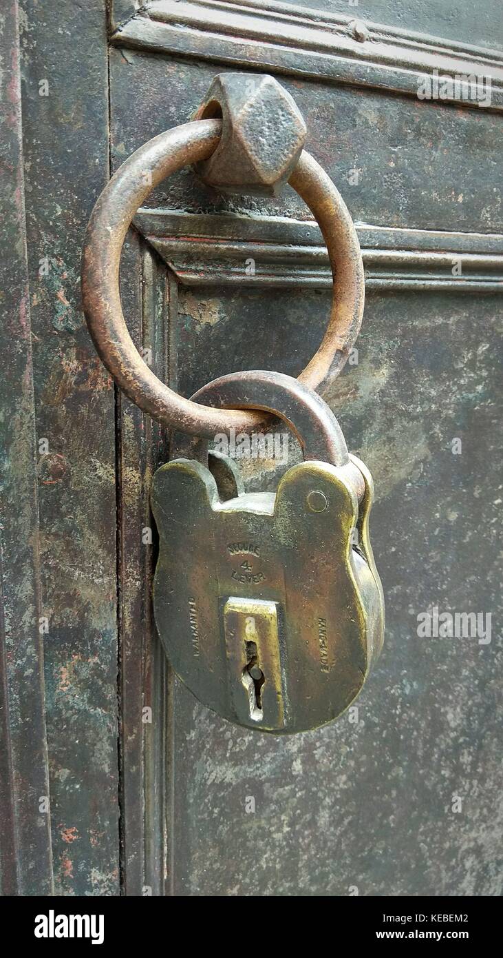 Vecchio arrugginito lucchetto sulla porta di bronzo Foto Stock