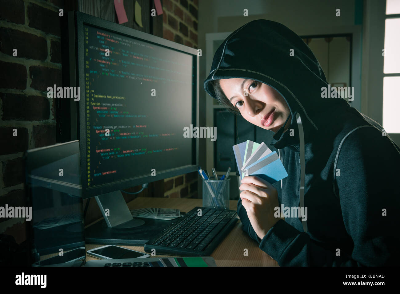 Attraente bellezza ragazza hacker rubano molti e della carta di credito online utilizzando il sistema di codice per ottenere la password di account di preparare il ricatto di denaro. Foto Stock