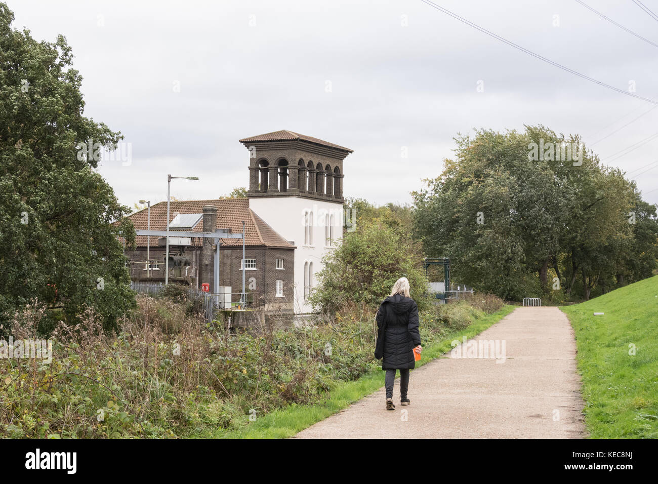 Un visitatore passeggiate accanto alla torre Coppermill a Walthamstow zone umide. Foto Stock