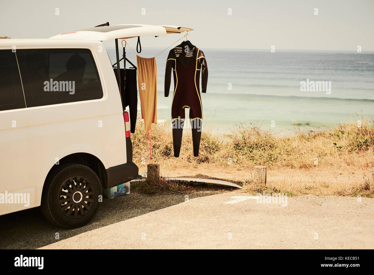 Un surfers van parcheggiato presso la spiaggia con un tipo di muta appendere fuori ad asciugare Foto Stock
