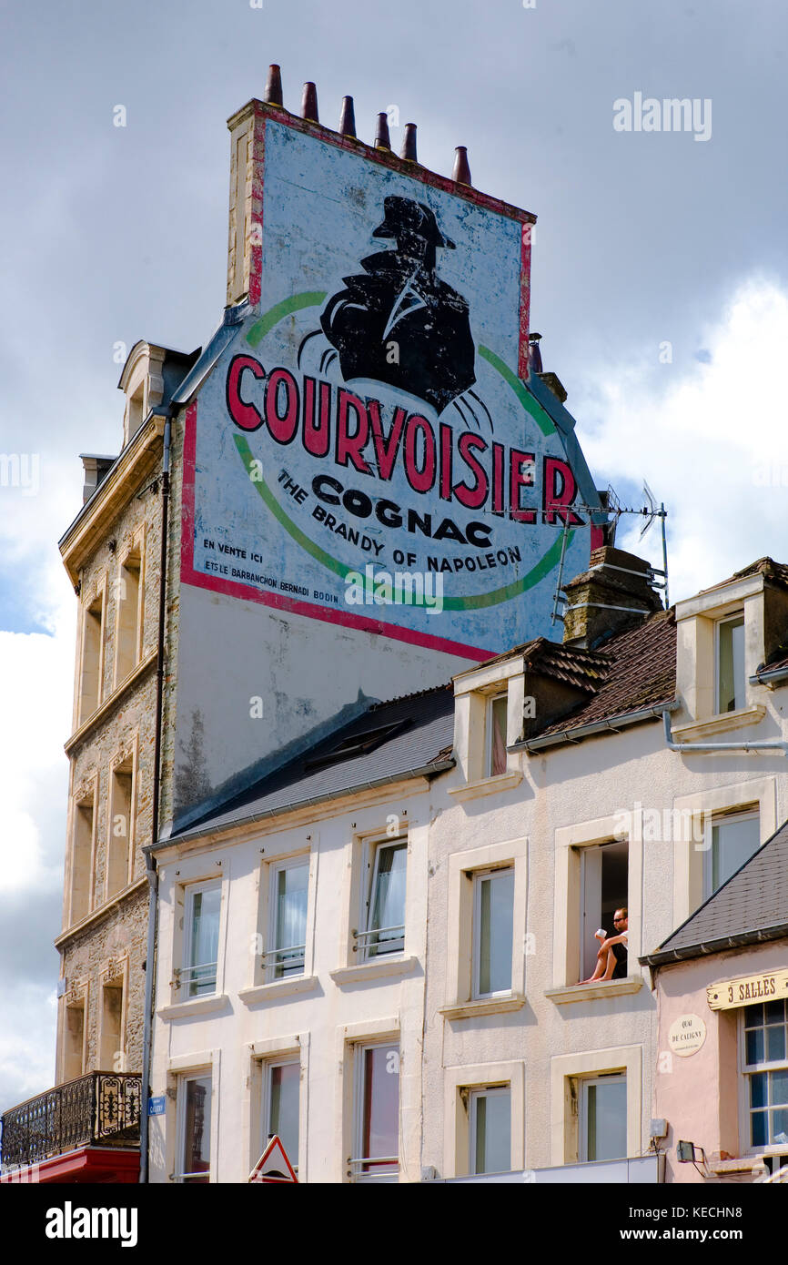 Old Courvoisier brandy pubblicità sul lato di una casa a Quai de Caligny, Cherbourg, Normandia, Francia Foto Stock